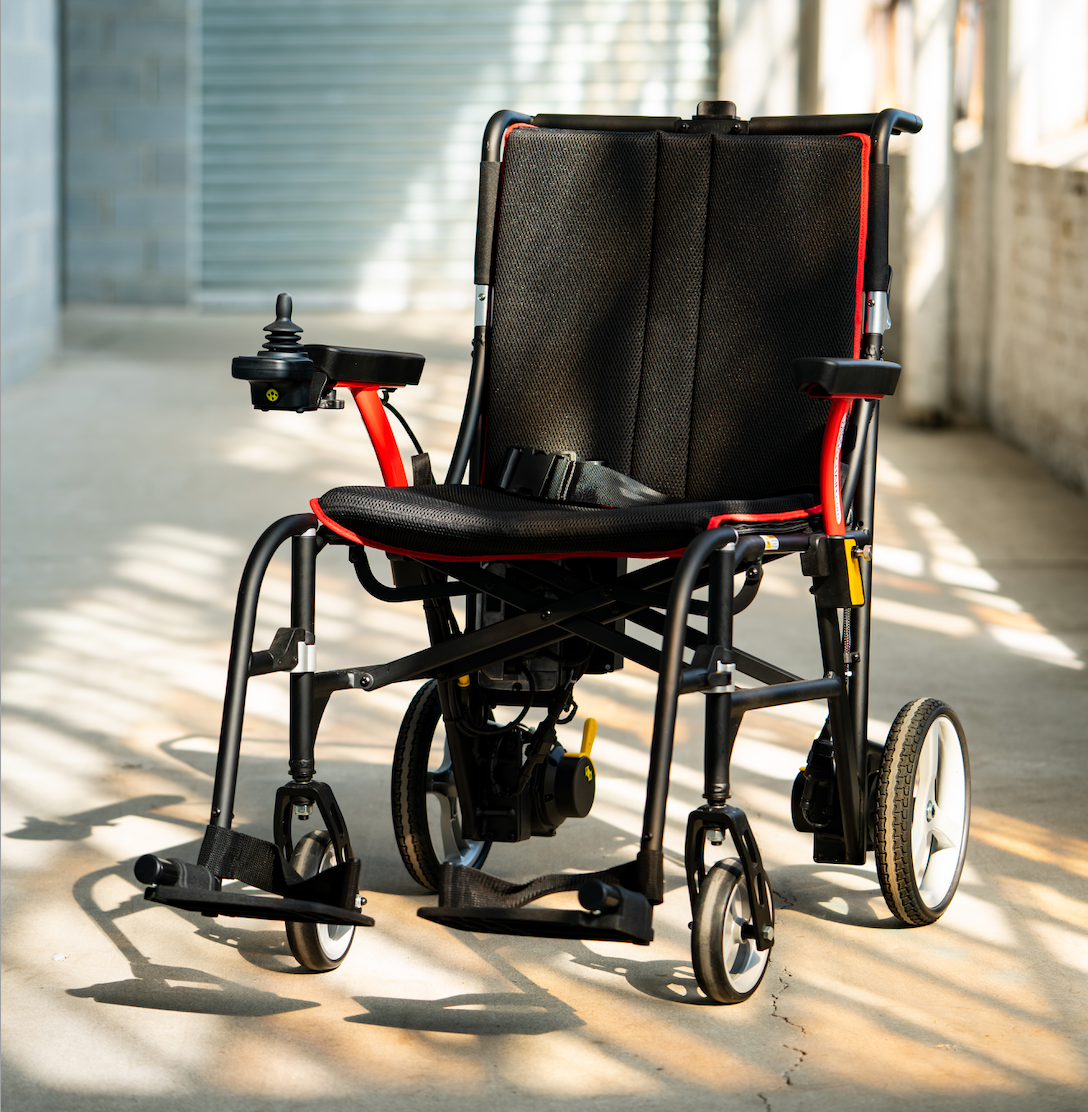 FEATHER POWER CHAIR lightweight electric wheelchair with black and red frame in bright indoor space