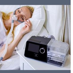 React Health Luna G3 CPAP machine on bedside table with woman sleeping using nasal mask