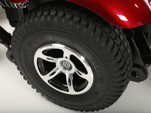 Close-up of rugged tire wheel on Merits Vision Sport Power Chairs with black and silver rim