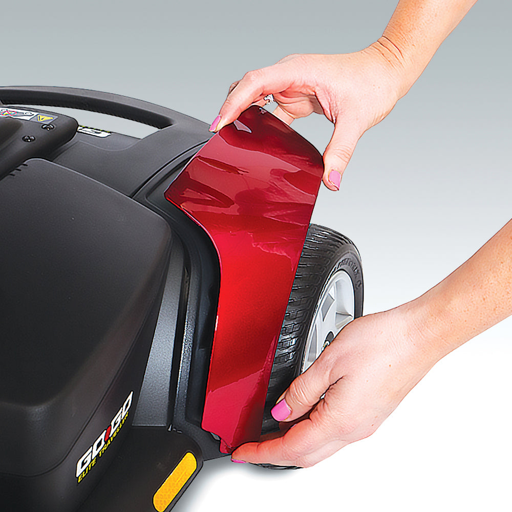 Hands removing red panel from Go Go Elite Traveller 3-Wheel Mobility Scooter by Pride Mobility showing tire and frame details