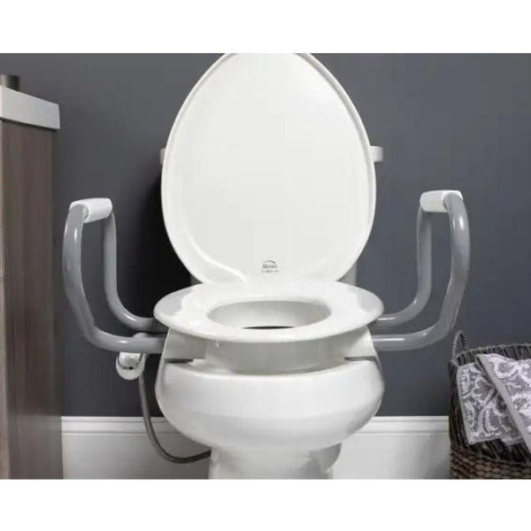 White Bemis Clean Shield Raised Toilet Seat with gray safety arms installed on a toilet