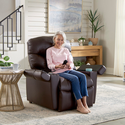GOLDEN TECHNOLOGIES Cloud Plus With MaxiComfort Power Lift Recliner in brown, woman using remote