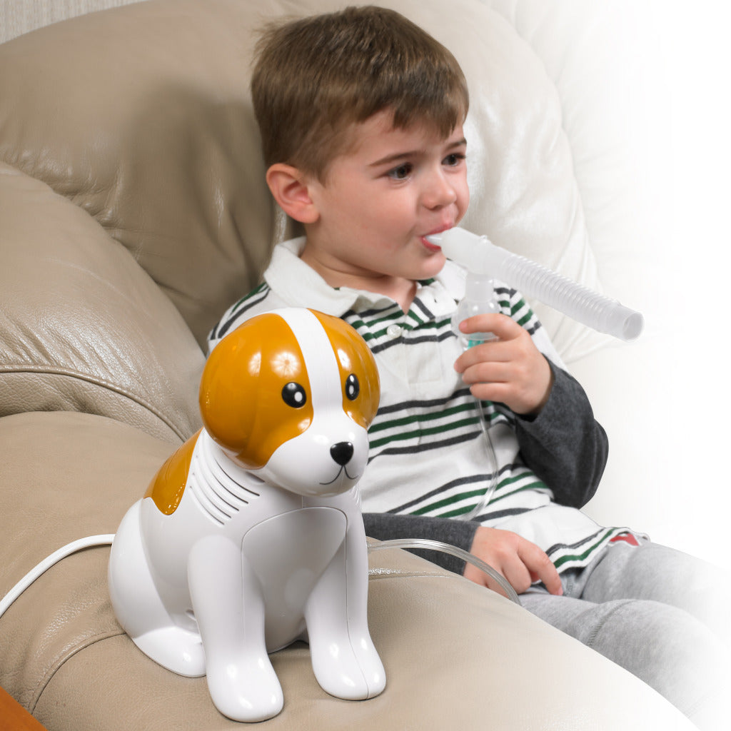 Beagle Pediatric Compressor Nebulizer by Drive Medical toy dog design with young boy using mouthpiece on couch