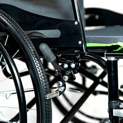 Close-up of Feather wheelchair brake and wheel assembly showing black frame and green-trimmed seat FEATHER CHAIR HD - 15 LBS