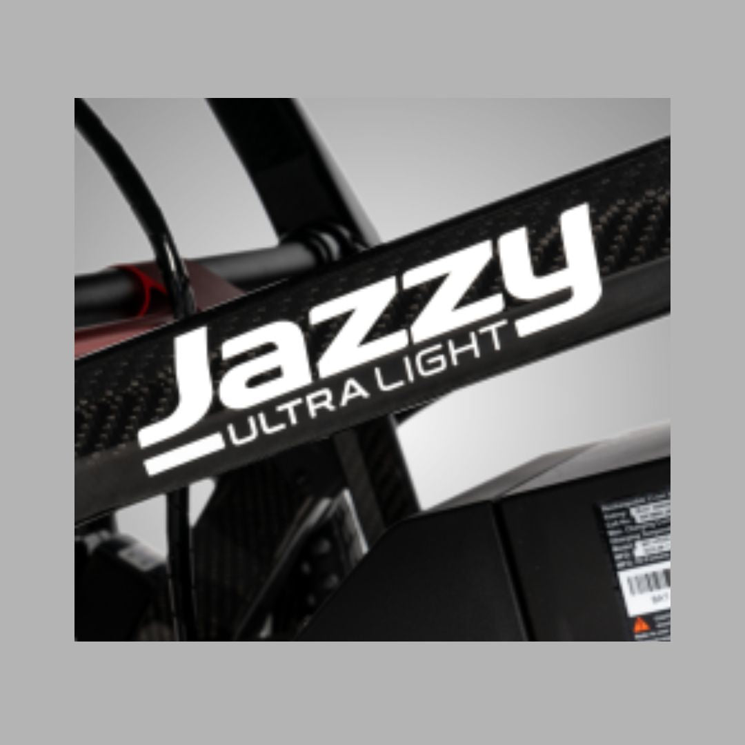 Pride Mobility Jazzy Ultra Light Carbon Fiber Foldable Power Chair close-up view of logo