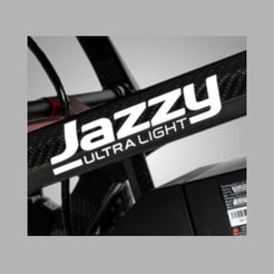 Pride Mobility Jazzy Ultra Light Carbon Fiber Foldable Power Chair close-up view of logo