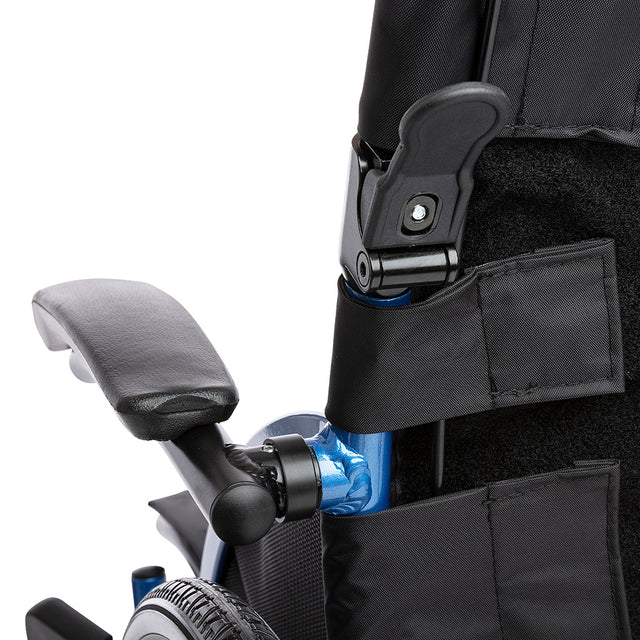 Close up of STRONGBACK 24 Flip Wheelchair 1019 padded flip back armrest with folding latch and backrest pocket and rear wheel
