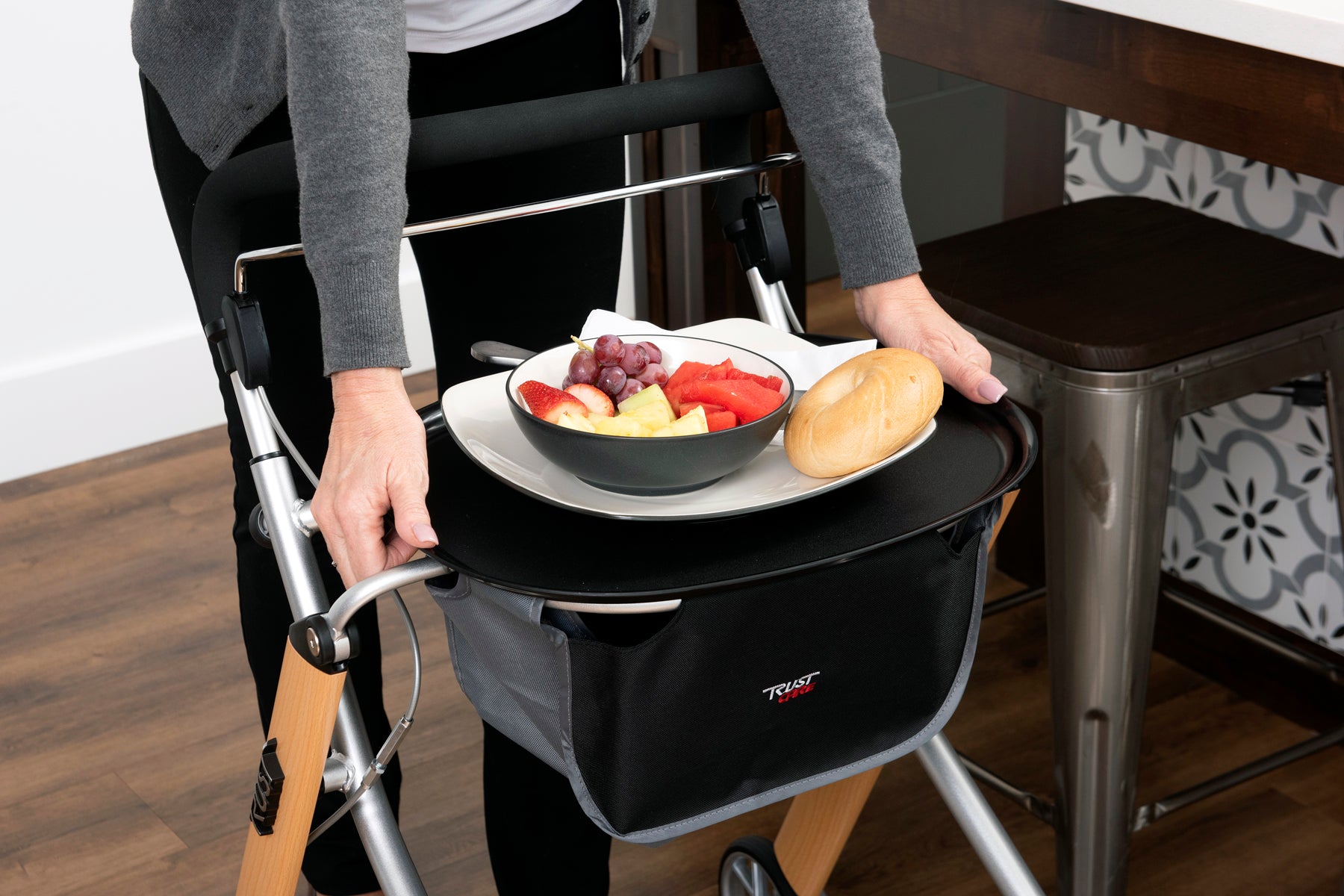 Trust Care Lets Go Indoor Rollator Walker with tray holding food and bread on wooden floor