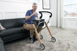 Man using Trust Care Lets Go Indoor Rollator Walker with wooden frame and black handle indoors